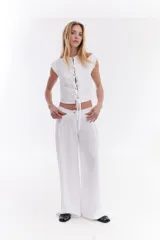 Pantalón sastrero de lino italiano color beige, de corte recto y holgado, con aberturas laterales en la cintura y pinzas.