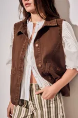 Chaleco oversize de algodón color marrón con efecto lavado, cuello solapa y cierre frontal con botones metálicos. Cuenta con bolsillos frontales diagonales.