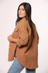 Camisa de pana fina color beige, con cuello clásico, cierre frontal de botones y dos bolsillos con solapa en el pecho.