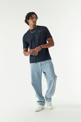 Jean de corte baggy con tiro medio, diseño amplio en piernas y cadera, con cierre y botón frontal.