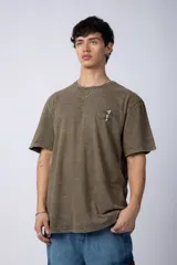 Remera de corte semi-oversize en color naranja con efecto de lavado tipo snow. Presenta un pequeño estampado gráfico en el pecho y cuello redondo.