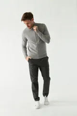 Campera tejida gris con cierre frontal, cuello alto y logo bordado en el pecho.