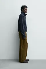 Sudadera de corte relajado confeccionada en tejido de algodón con textura waffle. Presenta cuello subido con cierre frontal de cuatro botones y mangas largas con puños y ruedo en rib.