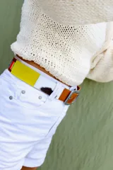 Cinturón de cuero marrón combinado con inserciones de gamuza, pelo vacuno y tejido tipo aguayo de colores. Cuenta con hebilla metálica rectangular envejecida.