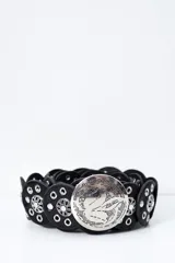 Cinto de cuero negro compuesto por piezas circulares unidas entre sí, decoradas con remaches metálicos y detalles florales plateados. Incluye una hebilla circular grande de metal plateado con diseño grabado.