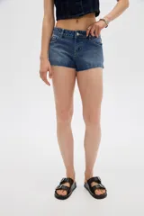 Short de jean tiro bajo y calce ajustado, con dobladillos deshilachados.
