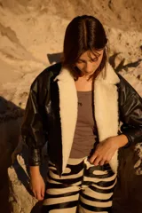 Campera de cuero oversize con solapa amplia de corderito, mangas anchas y detalle de cuero trenzado en la parte delantera.