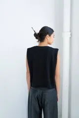 Chaleco de punto calado celeste con diseño estampado en negro y cierre frontal mediante tiras tejidas a crochet.