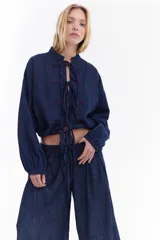 Blusa de denim liviano, estilo oriental con cierre frontal de lazos y costuras a contratono.
