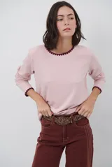 Remera de manga larga en color azul marino, confeccionada en tejido suave. Presenta un delicado detalle de bordado festoneado en color blanco tanto en el cuello redondo como en los puños, aportando un toque distintivo a esta prenda básica.