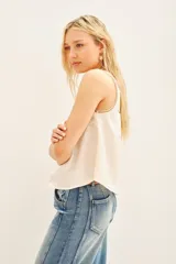 Top tipo musculosa de modal satén color crema, con detalle de encaje calado y bordados a tono en el escote delantero y en la espalda.