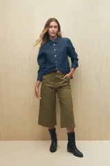 Pantalón capri color verde militar, de corte acampanado, con bolsillos laterales tipo cargo y cintura con cordón ajustable.