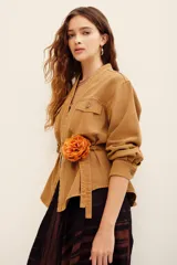 Kimono de algodón color tostado, de manga larga, con bolsillos frontales con solapa y detalle de cinto incorporado.