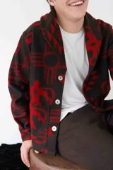 Cardigan de paño de lana con diseño de inspiración navajo en colores negro y azul. Presenta cuello smoking, cierre frontal con botones de guampa, bolsillos delanteros y puños con botón.