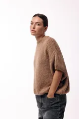 Sweater de tejido de punto grueso con silueta amplia y mangas 3/4. Presenta cuello redondo y una textura voluminosa, ideal para un look relajado y sofisticado.