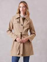 Gabardina trench de tejido repelente al agua en color beige. Presenta cuello con solapa ancha, cierre frontal con botones en tono carey, capucha desmontable y lazo de ajuste en la cintura. Incluye bolsillos laterales tipo ojal y forro interno a tono.