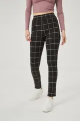 Calza larga negra con estampado de cuadros blancos.