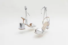 Sandalias negras de cuero con tacón cuadrado y tiras finas para atar al tobillo.