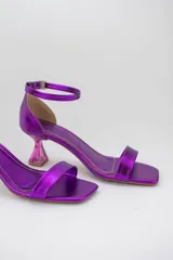 Sandalias negras con punta cuadrada, tira delantera fina y pulsera ajustable al tobillo. Destacan por su taco geométrico transparente de altura media.