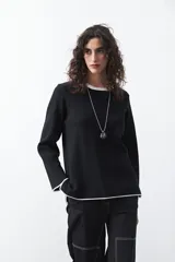 Sweater de tejido de punto con silueta recta y calce relajado. Presenta un diseño liso en color negro con detalles de vivos en contraste color blanco en el cuello redondo, los puños y el ruedo.