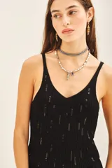 Musculosa de tejido rib al cuerpo con escote en V y detalle de lentejuelas bordadas a tono.