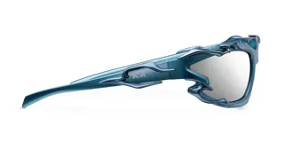Lentes de sol con montura envolvente de color azul metalizado, con detalles decorativos de líneas orgánicas en los laterales. Cuentan con lentes de nylon en color gris y protección UV400.