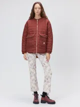 Campera capitoneada reversible de color bordó, con diseño liviano, cuello redondo, cierre frontal y dos bolsillos delanteros con solapa.