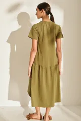 Vestido midi color crudo de manga corta, con corte en la cintura y falda holgada con volados y detalle de pequeño bordado de hongo en el pecho.