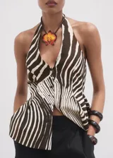 Chaleco tipo peplum con estampado de cebra en tonos marrón y blanco, cuello halter y cierre frontal con botones.