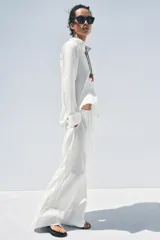 Pantalón palazzo de lino color rosado, con cintura elástica ajustable con cordón y bolsillos laterales ocultos.