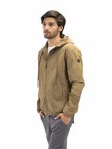 Campera rompevientos de nylon color negro, con capucha ajustable, cierre frontal, bolsillos laterales con cierre y forro interno de red para mayor ventilación.