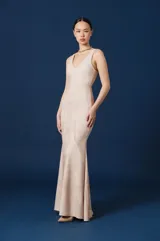 Vestido largo de corte sirena con escote en V y breteles anchos. Presenta un estampado integral que simula texturas de plumas en tonos azules degradados.