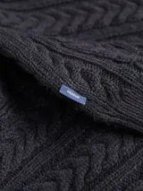 Sweater de punto con cuello alto y manga larga, de corte regular. Presenta un diseño con textura de ochos verticales en toda la prenda, con puños y ruedo acanalados.