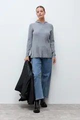 Hoodie de tejido de punto con textura de ochos, manga larga y capucha. Presenta un corte recto con aberturas laterales en el ruedo.