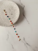 Pulsera de cadena fina de acero quirúrgico con pequeñas cuentas facetadas de colores variados.