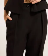 Pantalón de vestir negro, de corte recto, con trabillas en la cintura y cierre tradicional de botón y cremallera.