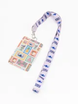 Tarjetero con porta credencial y correa de cuello larga, con diseño estampado de Stitch y motivos hawaianos. La correa es de color lila con el nombre del personaje repetido.