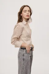 Camisa de manga larga con diseño de rayas verticales en tonos celestes, blancos y marrones, confeccionada en tejido semitransparente con cuello camisero y cierre frontal de botones.