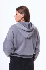 Buzo tipo canguro de felpa con efecto lavado, color violeta, con capucha, bolsillo frontal tipo canguro y mangas largas con puños ajustados.