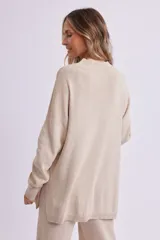 Sweater de punto color beige melange, de corte amplio y cuello alto.