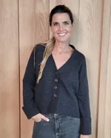 Cardigan de lana lambswool con escote en V, cierre frontal con botones y mangas largas con puños anchos. Diseño clásico de tejido de punto.