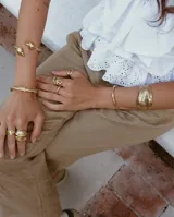 Brazalete rígido plateado con textura irregular.