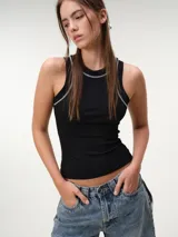 Musculosa de tela rib color marfil, con escote nadador, corte ajustado al cuerpo y costuras a contratono en color marrón.