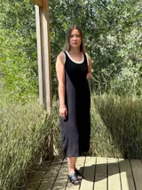 Vestido midi negro de corte recto con volados blancos en el cuello y sisas.