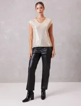 Blusa sin mangas con escote en V, confeccionada completamente en lentejuelas color dorado. Cuenta con forro interno a tono y un corte recto y holgado.