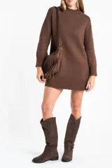 Vestido corto de punto color marrón, con cuello alto, mangas largas con puños acanalados y ruedo acanalado. Presenta un diseño de corte recto y holgado.
