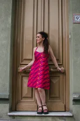 Vestido corto con estampado abstracto en tonos fucsia, rojo y naranja. Diseño con espalda descubierta, corte en A y breteles finos.