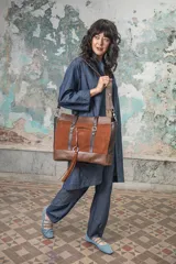 Bolso de mano rectangular con frente de gamuza color terracota y base, laterales y asas en cuero vacuno graneado color chocolate. Incluye asas de mano y correa bandolera regulable y desmontable.