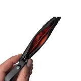 Billetera tipo pouch color negro, fabricada en material impermeable xPac X21. Cuenta con cierre principal, bolsillo frontal con cierre y tiradores ergonómicos. Incluye tecnología de bloqueo RFID.
