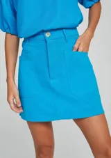 Pollera corta celeste con bolsillos delanteros.